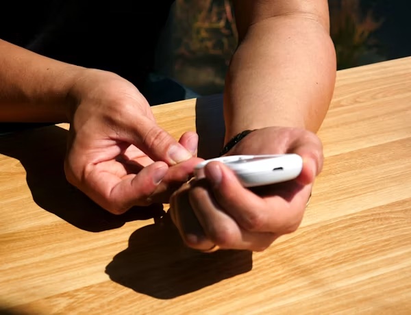 Hands holding a glucometer
