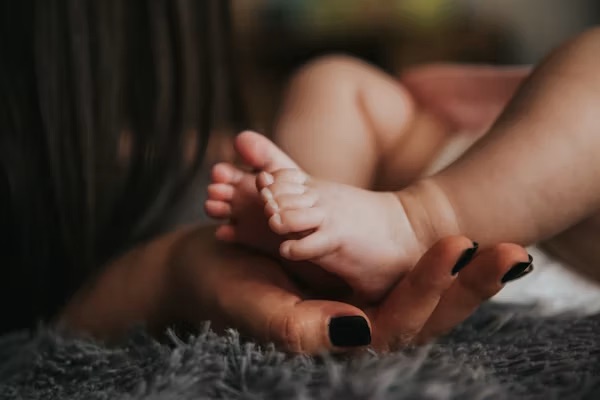Newborn's feet held in a mother's hand